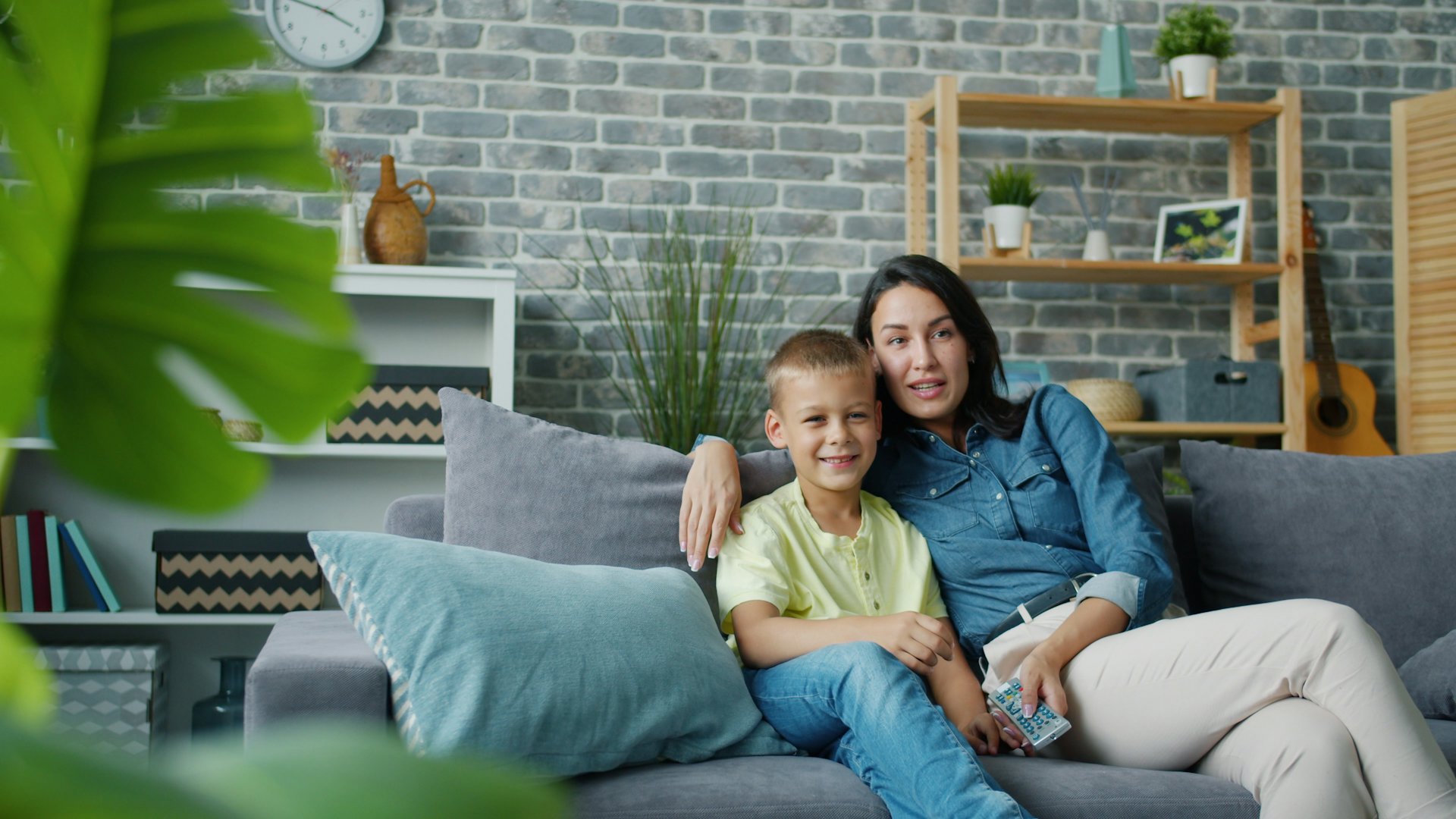 Mother and son sitting together on the living room sofa