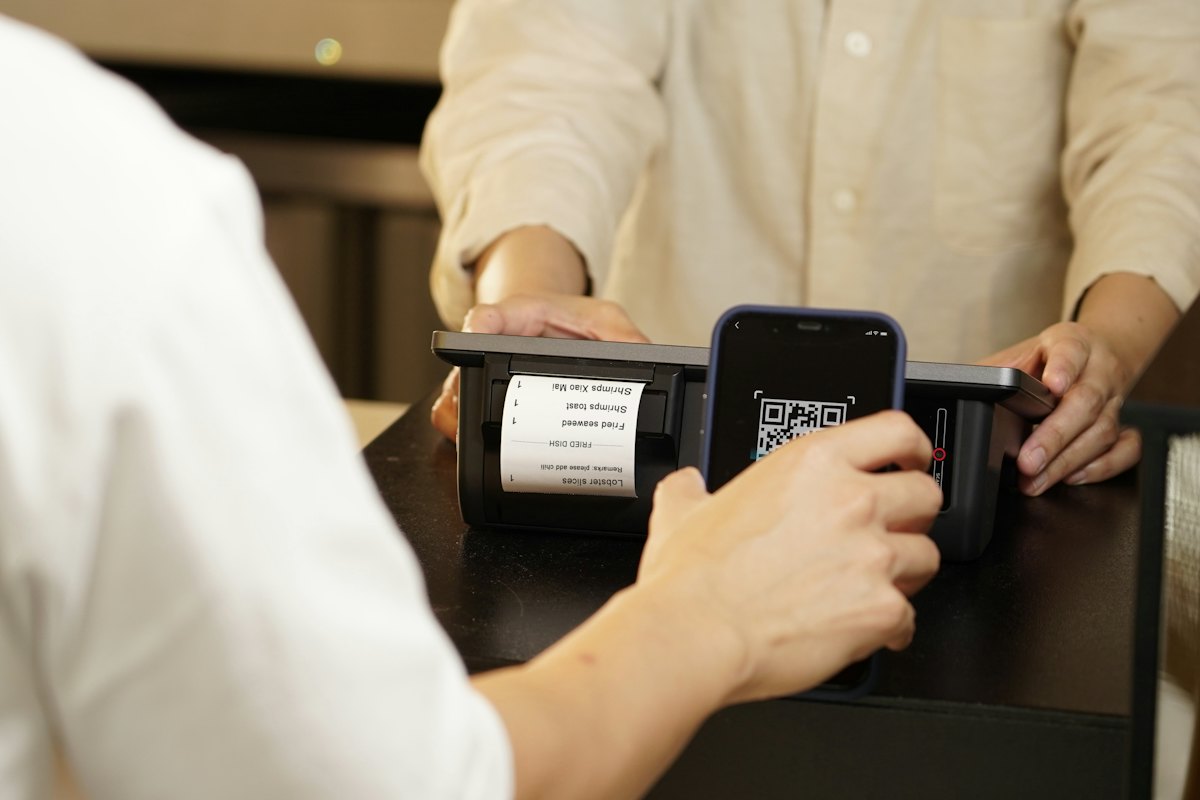 Shopper scanning a QR code with a phone at a checkout counter