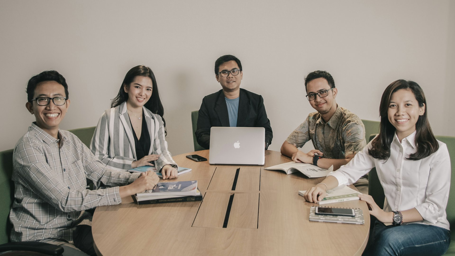 Tim kantor rapat di meja bundar dengan laptop